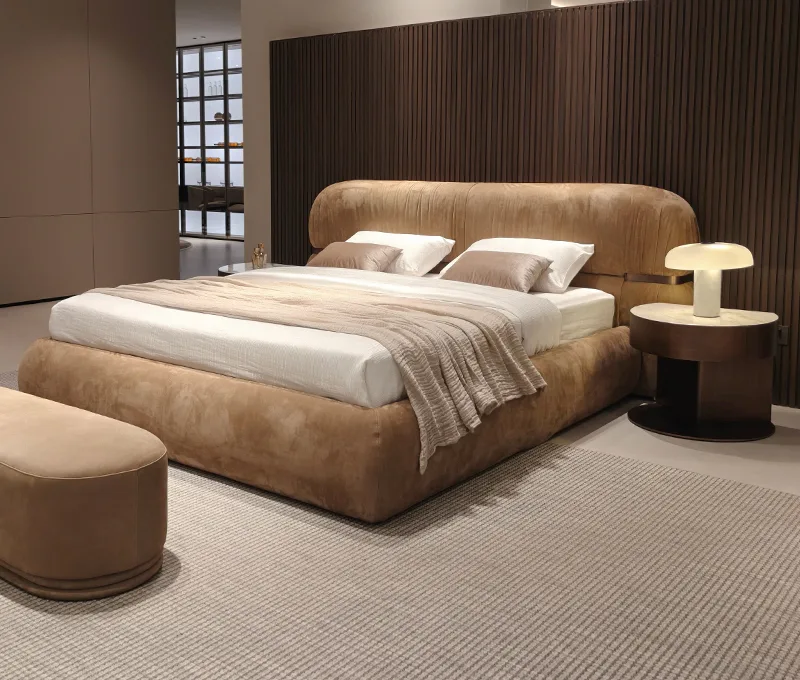 Tan upholstered bed with sculpted headboard